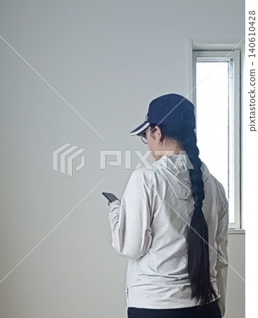 一名女子邊走邊看手機。 一名女子邊走邊看手機。 140610428