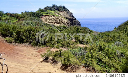 東京小笠原群島的母島山坡上,紅色的土崖和大海綿延不絕。 東京小笠原群島的母島山坡上,紅色的土崖和大海綿延不絕。 140610685
