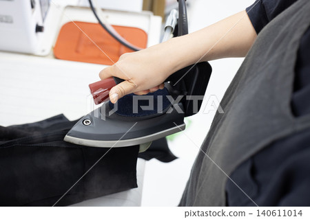 A scene of ironing with steam rising from the iron. A scene of ironing with steam rising from the iron. 140611014