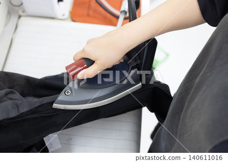 A scene of ironing with steam rising from the iron. A scene of ironing with steam rising from the iron. 140611016
