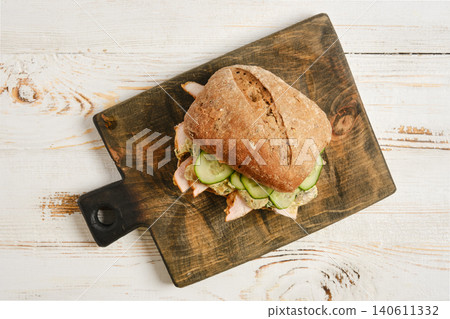 Sandwich with chicken, cucumber and creamy mushroom sauce on cutting board Sandwich with chicken, cucumber and creamy mushroom sauce on cutting board 140611332