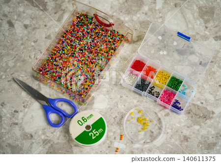 Close up of colorful seed beads in square sections pink shades, flat lay Close up of colorful seed beads in square sections pink shades, flat lay 140611375