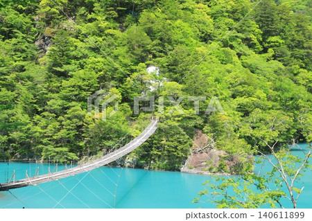 The view of the dream suspension bridge spanning the mysteriously shimmering lake in Sumatakyo Gorge. The view of the dream suspension bridge spanning the mysteriously shimmering lake in Sumatakyo Gorge. 140611899