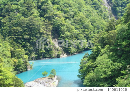 The scenery of the dream suspension bridge spanning the beautiful dam lake in Sumatakyo Gorge. The scenery of the dream suspension bridge spanning the beautiful dam lake in Sumatakyo Gorge. 140611926
