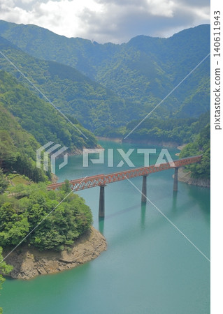 風景如畫的奧大井彩虹橋橫跨碧藍的湖泊。 風景如畫的奧大井彩虹橋橫跨碧藍的湖泊。 140611943