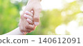 Adult and child holding hands outdoors on sunny day 140612091