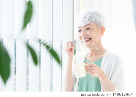 Senior woman brushing teeth Senior woman brushing teeth 140612404