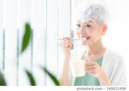 Senior woman brushing teeth Senior woman brushing teeth 140612406