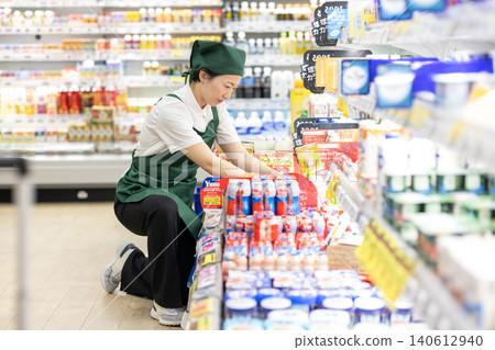 食品區的女員工正在整理貨架。 食品區的女員工正在整理貨架。 140612940