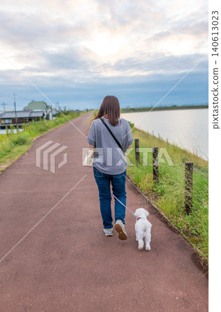 A woman's back view as she walks her dog along the edge of the Kakodaiike reservoir in Hyogo Prefecture. *Location of the photo is indicated in the comments section of the artwork. A woman's back view as she walks her dog along the edge of the Kakodaiike reservoir in Hyogo Prefecture. *Location of the photo is indicated in the comments section of the artwork. 140613023
