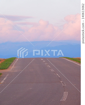 A summer evening scene of a road on a hill in Biei, Hokkaido, where the view beyond is obscured. A summer evening scene of a road on a hill in Biei, Hokkaido, where the view beyond is obscured. 140613062