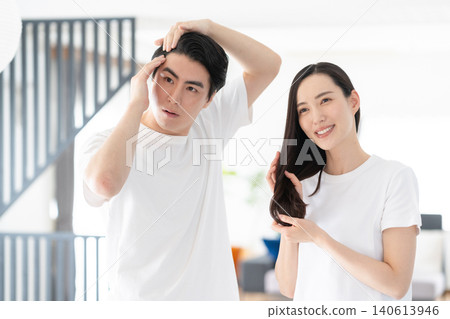 一對中年夫婦在客廳裡做頭髮護理。 140613946