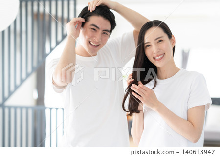 一對中年夫婦在客廳裡做頭髮護理。 140613947