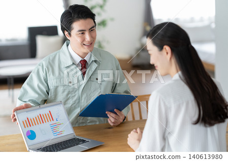 A housewife and a construction worker discussing renovation plans. A housewife and a construction worker discussing renovation plans. 140613980