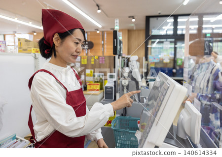 超市的兼職女收銀員和一位顧客。 140614334