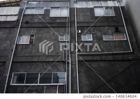 一座老舊的木質和混凝土建築的外牆,因年代久遠而佈滿雨水痕跡,既美麗又頹敗。 一座老舊的木質和混凝土建築的外牆,因年代久遠而佈滿雨水痕跡,既美麗又頹敗。 140614604