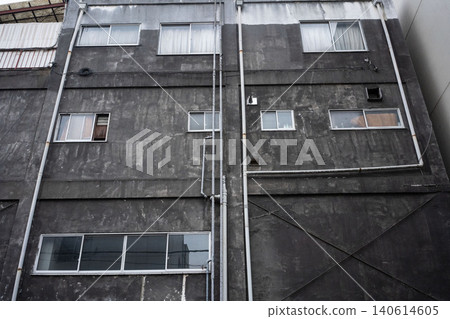 一座老舊的木質和混凝土建築的外牆,因年代久遠而佈滿雨水痕跡,既美麗又頹敗。 一座老舊的木質和混凝土建築的外牆,因年代久遠而佈滿雨水痕跡,既美麗又頹敗。 140614605