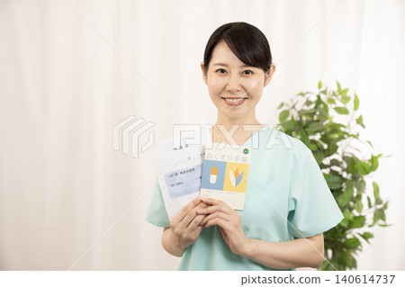 一名護士拿著用藥記錄簿和藥袋。 140614737