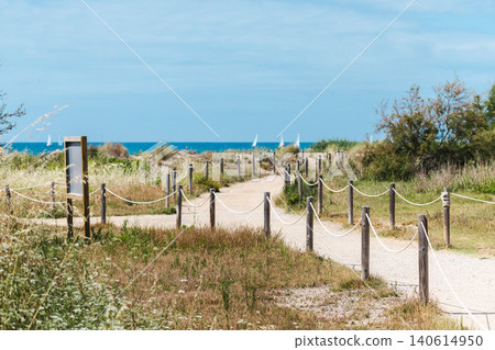 Coastal nature trail leading through protected dunes toward Mediterranean Sea near Les Madrigueres reserve in Sant Salvador, Catalonia, Spain Coastal nature trail leading through protected dunes toward Mediterranean Sea near Les Madrigueres reserve in Sant Salvador, Catalonia, Spain 140614950