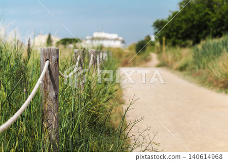 Nature trail with wooden rope fence in Les Madrigueres wetland reserve, shallow depth of field highlighting protected landscape and visitor pathway Nature trail with wooden rope fence in Les Madrigueres wetland reserve, shallow depth of field highlighting protected landscape and visitor pathway 140614968
