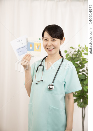 一名護士拿著用藥記錄簿和藥袋。 一名護士拿著用藥記錄簿和藥袋。 140614973