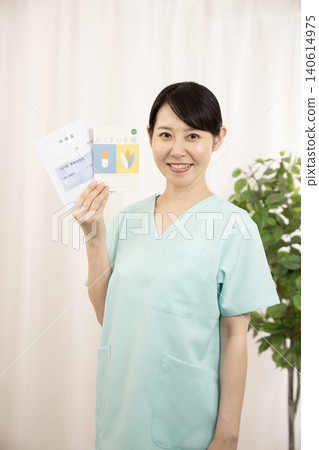 一名護士拿著用藥記錄簿和藥袋。 一名護士拿著用藥記錄簿和藥袋。 140614975