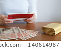 一位女士正在查看她的銀行存摺。 140614987