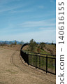A snow-covered mountain peeking out from the back of the park on a sunny day. 140616155