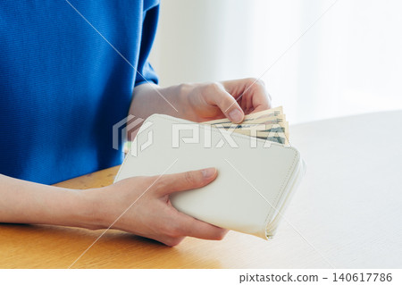 A young woman's hand holding a wallet A young woman's hand holding a wallet 140617786