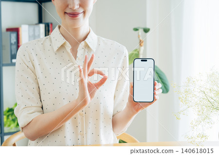 Young woman using a smartphone at home Young woman using a smartphone at home 140618015