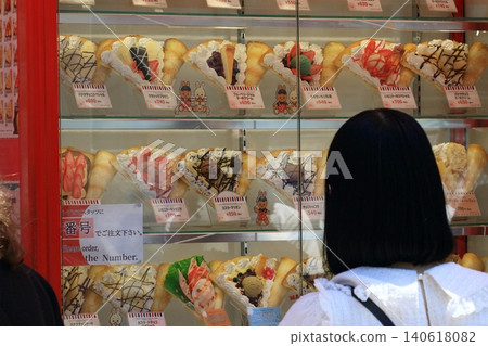 一位女士正在挑選可麗餅;可麗餅店的產品樣品;多種口味的可麗餅。 一位女士正在挑選可麗餅;可麗餅店的產品樣品;多種口味的可麗餅。 140618082