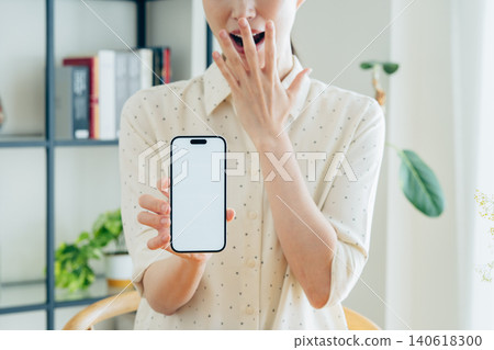 Young woman using a smartphone at home Young woman using a smartphone at home 140618300