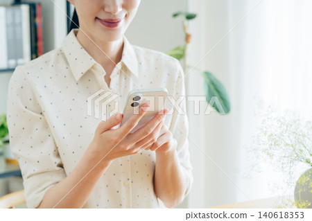 Young woman using a smartphone at home 140618353