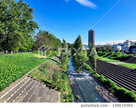 Scenery of the Kotoni-Hassamu River riverside green space in Nishi Ward, Sapporo City, with fresh greenery and a blue sky. Scenery of the Kotoni-Hassamu River riverside green space in Nishi Ward, Sapporo City, with fresh greenery and a blue sky. 140619365