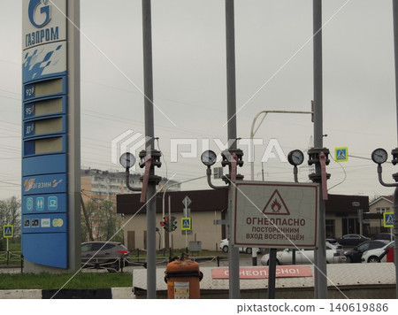 Maykop, Adygea, Russia - June 15, 2026: A tall blue-gray structure with a Gazprom sign and empty price columns for all types of gasoline, a white sign with Russian text against a background of pipes Maykop, Adygea, Russia - June 15, 2026: A tall blue-gray structure with a Gazprom sign and empty price columns for all types of gasoline, a white sign with Russian text against a background of pipes 140619886