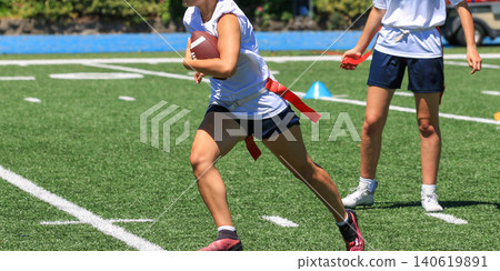 High School Girl Running with the Football During a Flag Football Game High School Girl Running with the Football During a Flag Football Game 140619891