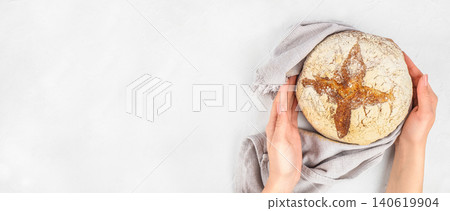 Hands holding artisan sourdough bread on light background, homemade bakery concept with copy space Hands holding artisan sourdough bread on light background, homemade bakery concept with copy space 140619904
