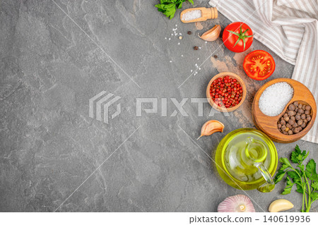 Cooking ingredients with olive oil tomato garlic and spices on dark stone background with copy space Cooking ingredients with olive oil tomato garlic and spices on dark stone background with copy space 140619936