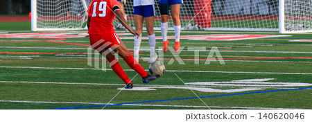 Soccer player in red uniform taking a penalty kick during a game 140620046
