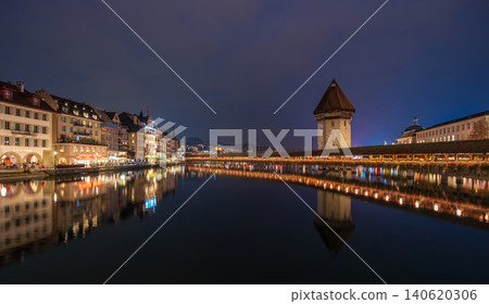 The illuminated Chapel Bridge over the Reuss River and the night view of Wasserturm. Lucerne, Switzerland The illuminated Chapel Bridge over the Reuss River and the night view of Wasserturm. Lucerne, Switzerland 140620306