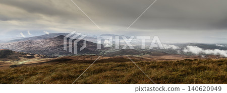 Grassy fields in varying shades of brown and gold cover the foreground slopes. Grassy fields in varying shades of brown and gold cover the foreground slopes. 140620949