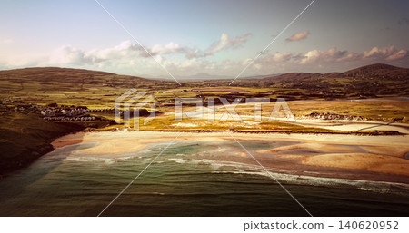 The ocean meets a sandy beach and estuary in this wide aerial shot of a rural coastal village. The ocean meets a sandy beach and estuary in this wide aerial shot of a rural coastal village. 140620952