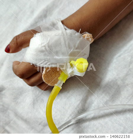 Small patient hand connected to intravenous drip for medication delivery. Small patient hand connected to intravenous drip for medication delivery. 140622158