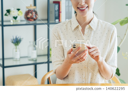 Young woman using a smartphone at home 140622295