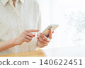 Young woman using a smartphone at home 140622451