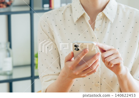 Young woman using a smartphone at home 140622453
