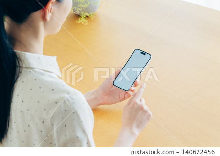 Young woman using a smartphone at home 140622456