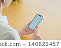 Young woman using a smartphone at home 140622457