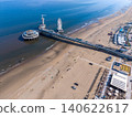 Aerial view of the famous Scheveningen Pier with a Ferris wheel, bungee jumping tower, sandy beach, and the North Sea coast in The Hague, Netherlands. 140622617
