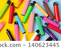 Colorful disposable electronic cigarettes on yellow and blue background. Top view. 140623445
